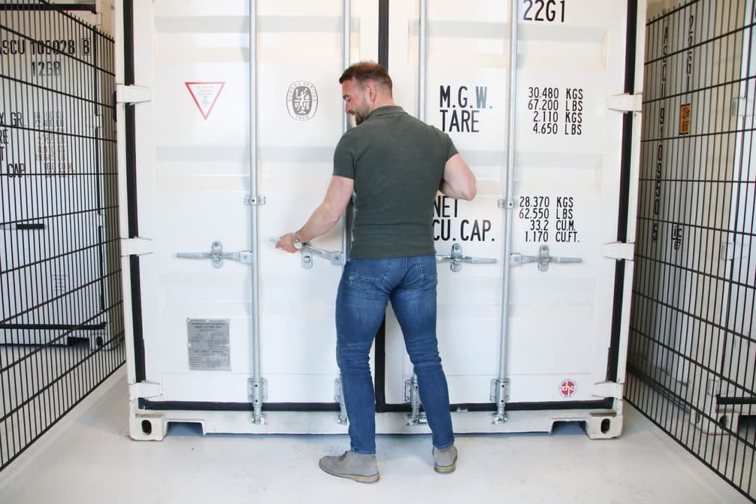 Klant sluit de deuren van zijn opslagcontainer in de self-storage van Oomen